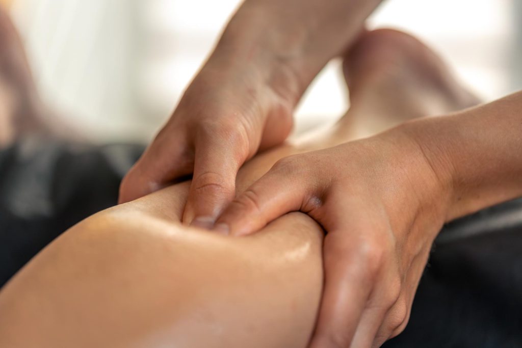 Physiotherapist performing trigger point therapy on a patient's leg muscle in Lucknow